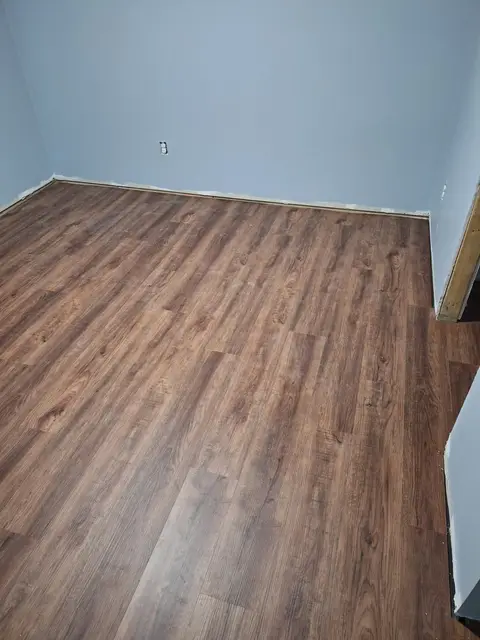 Brown wood-look vinyl plank floor in an empty room, Kings Mountain Tile project in North Carolina
