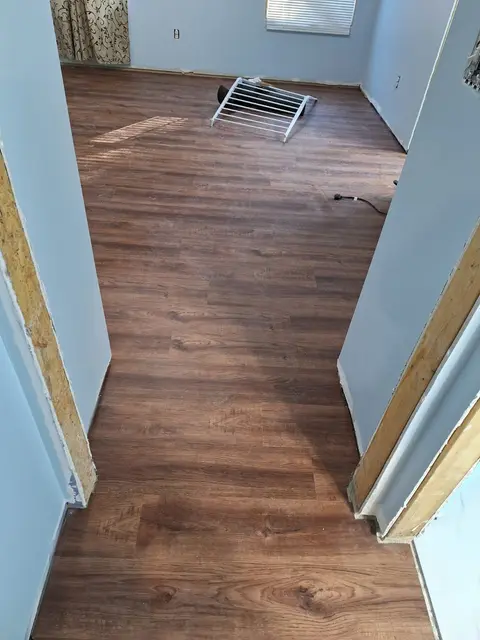 Dark wood-look vinyl plank flooring between two rooms, Kings Mountain Tile project in North Carolina