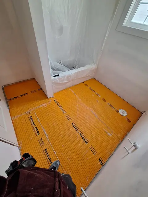 Shower floor waterproofed with orange Schluter membrane before tiling, Kings Mountain Tile project in North Carolina