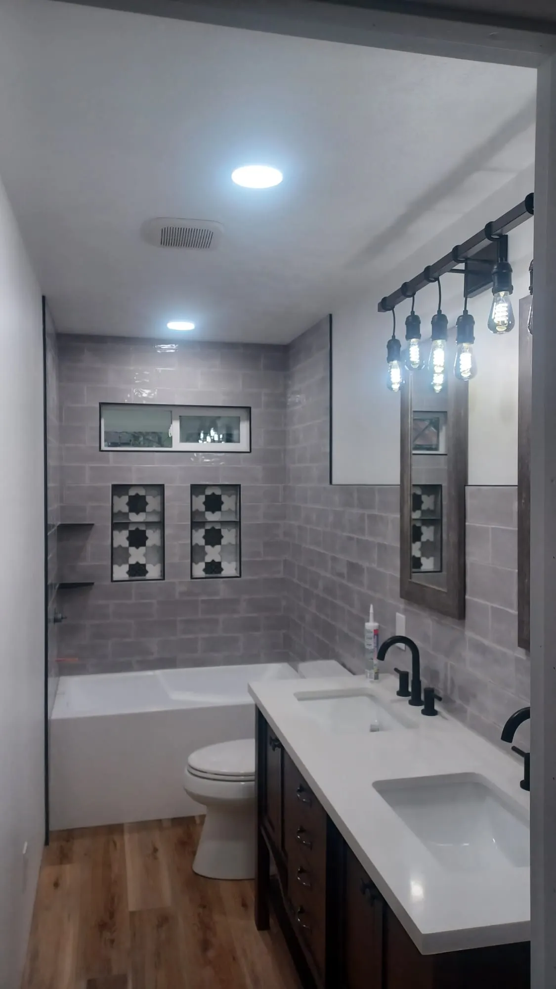 Bathroom remodel with gray tile walls, patterned accent tiles and double vanity, Kings Mountain Tile project in North Carolina