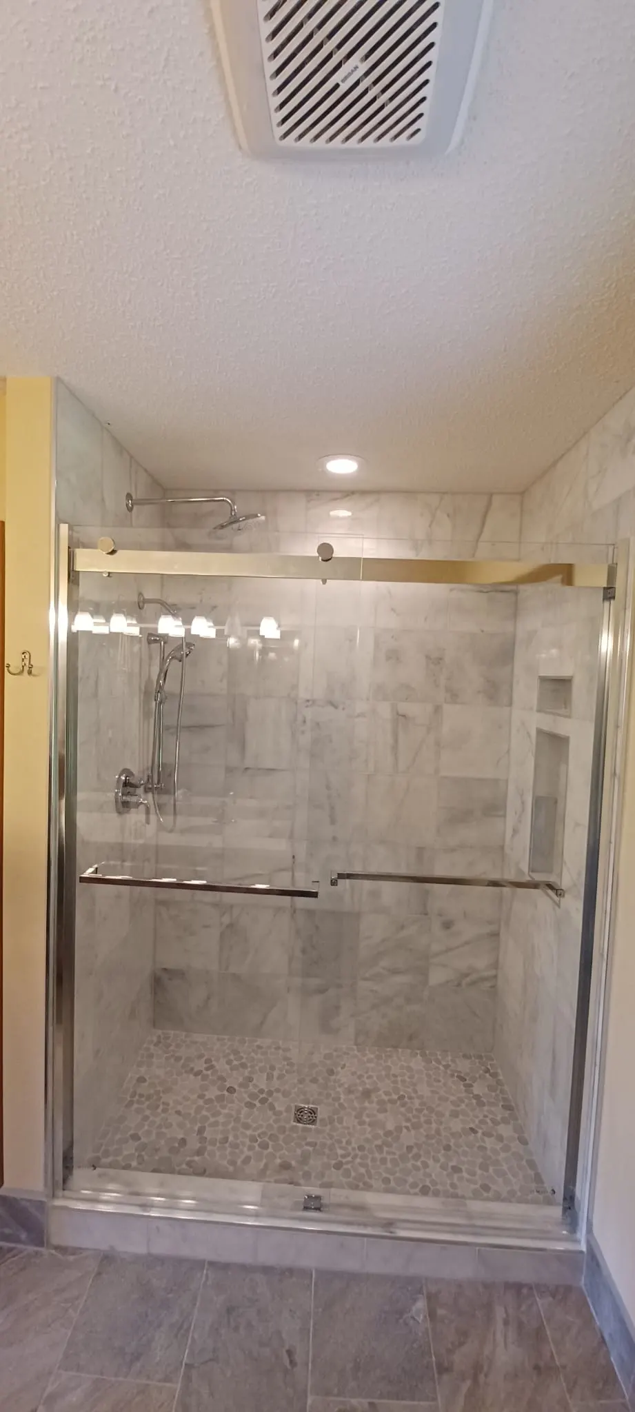 Marble tile shower with gold-trim sliding glass door, Kings Mountain Tile project in North Carolina