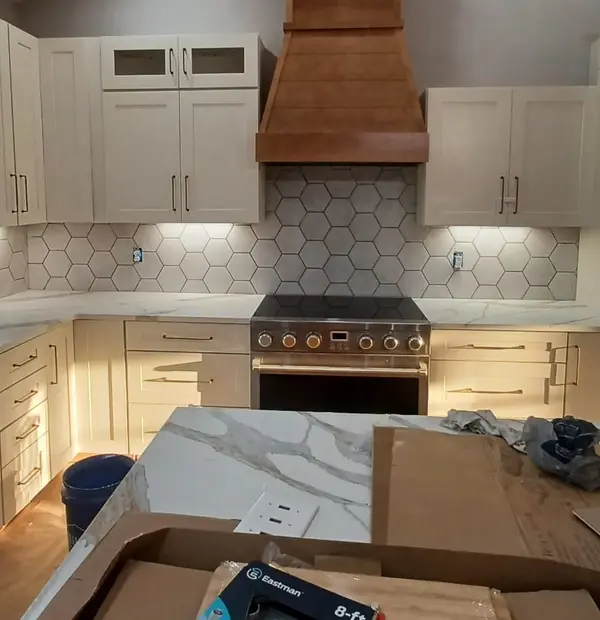 Kitchen hexagon tile backsplash above a marble countertop