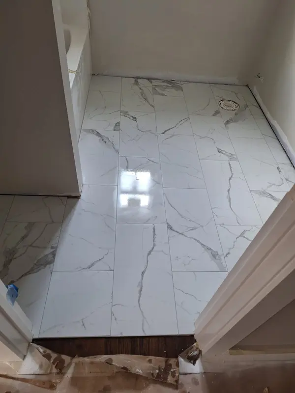 Polished marble-look porcelain tile floor installed by Kings Mountain Tile